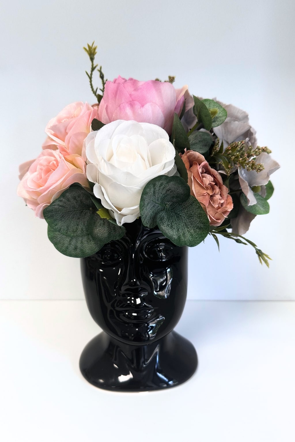 Soft colored flowers in a ceramic pot (head)